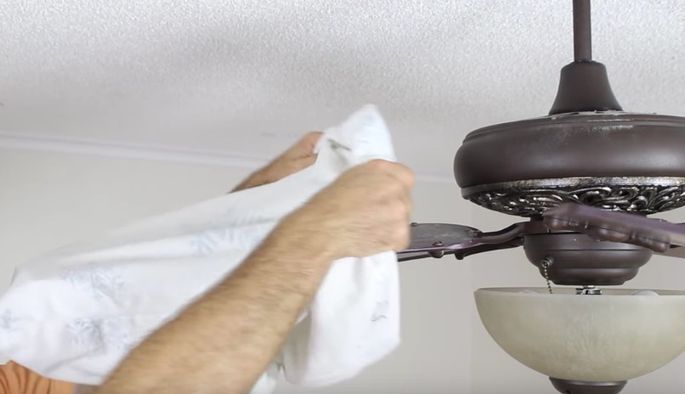 Use a pillowcase to clean a ceiling fan you can safely reach.