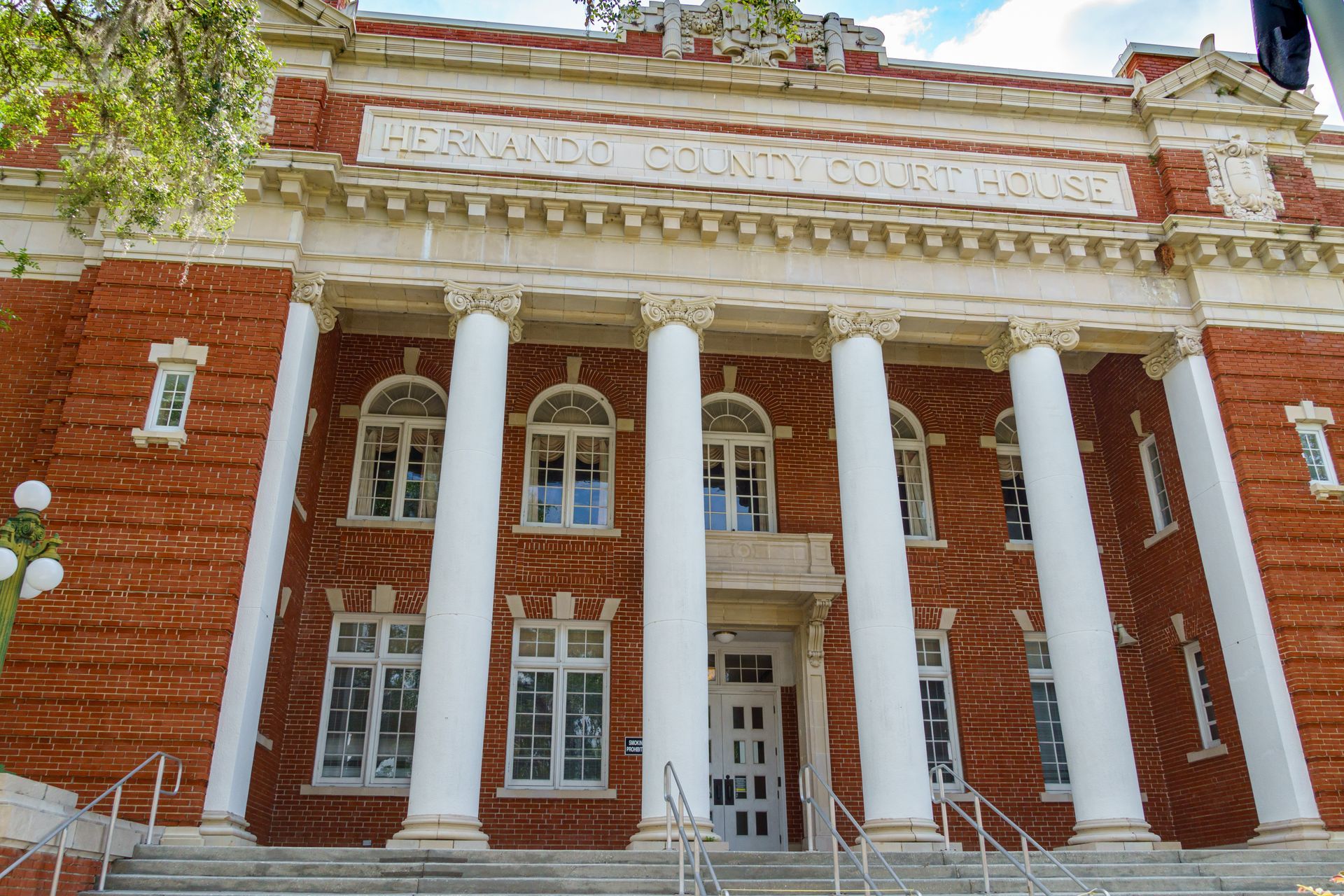 A large brick building with white columns and stairs