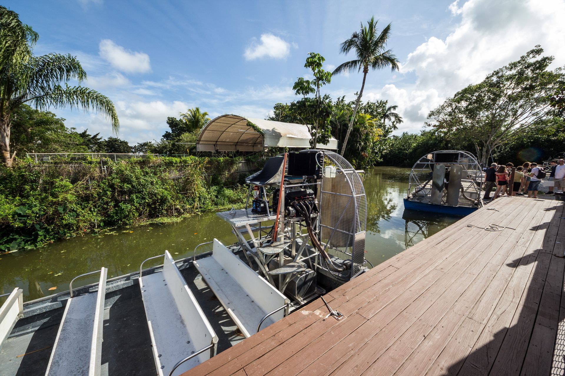 A group of people standing on a dock next to a boat