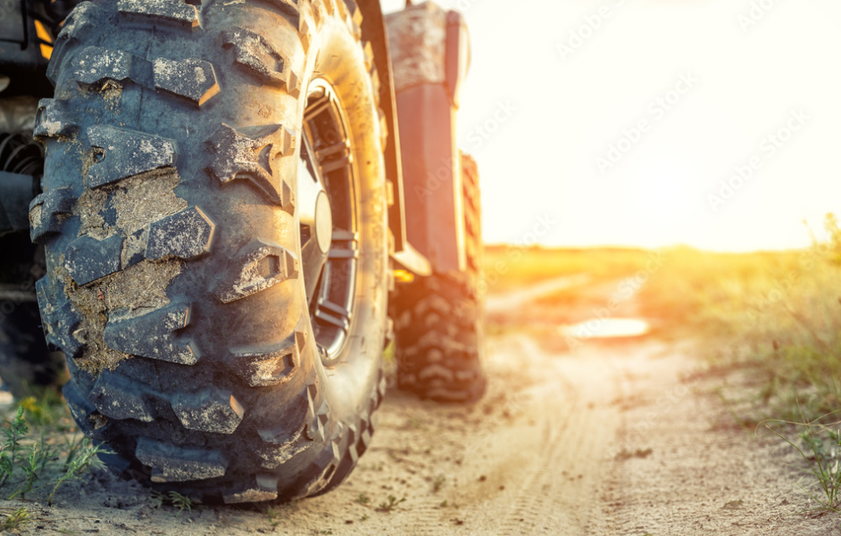 A close up of a tire on a dirt road.
