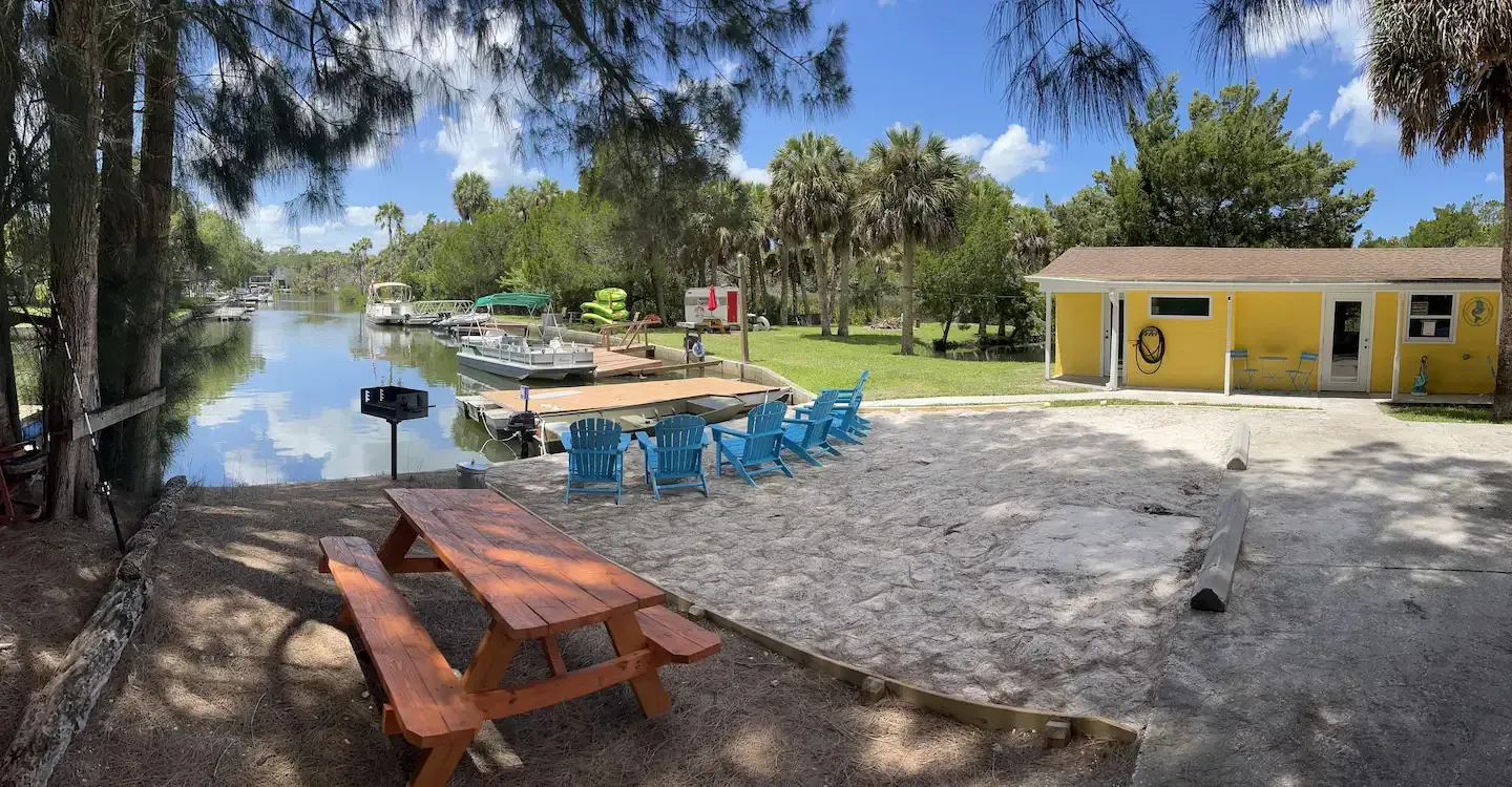 A picnic table is sitting on the beach next to a body of water.