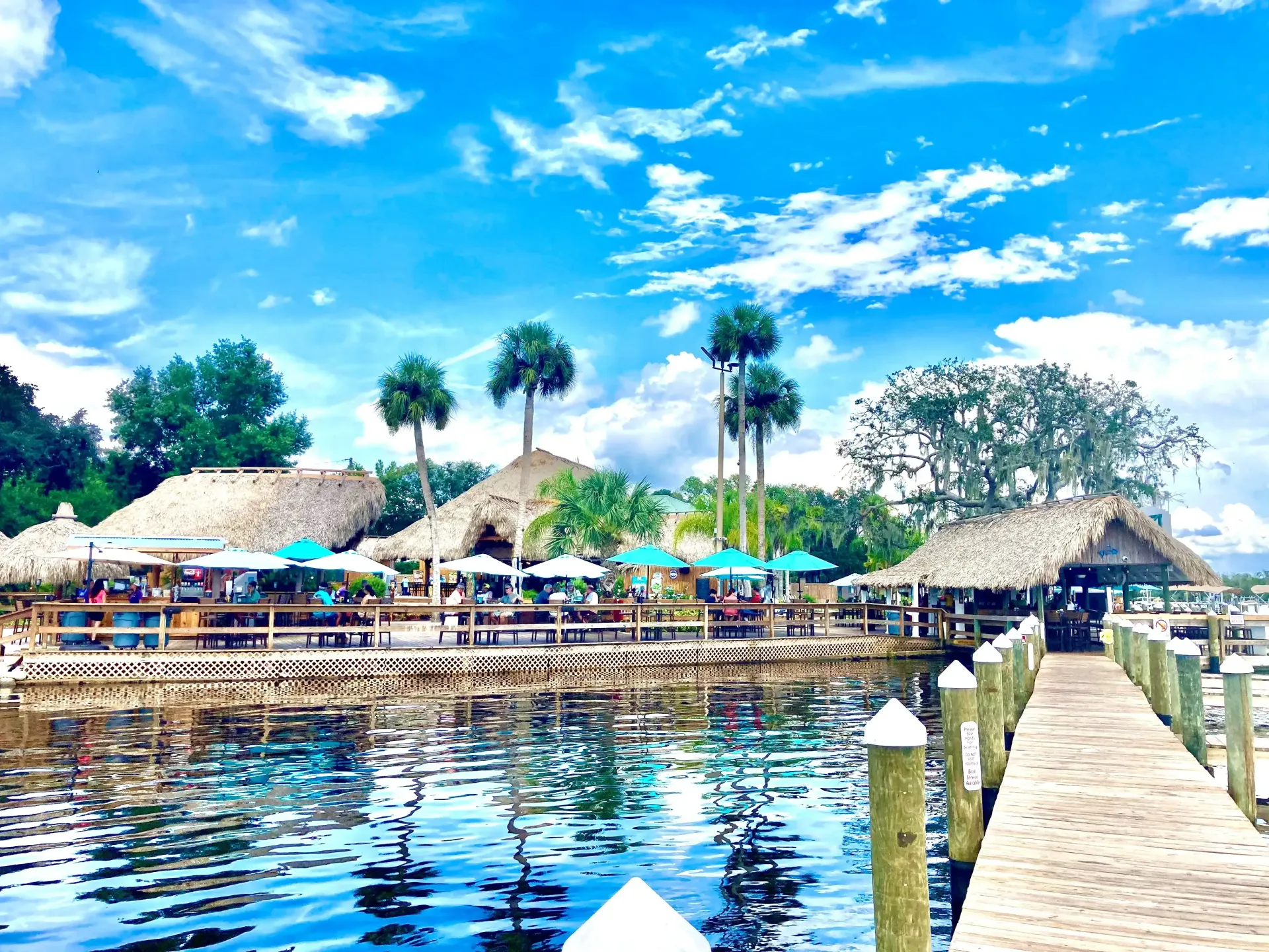 A dock leading to a restaurant on a tropical island