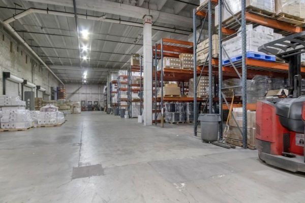 There is a forklift in the middle of the warehouse.