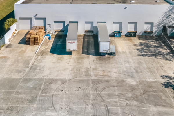 An aerial view of a warehouse with trucks parked in front of it
