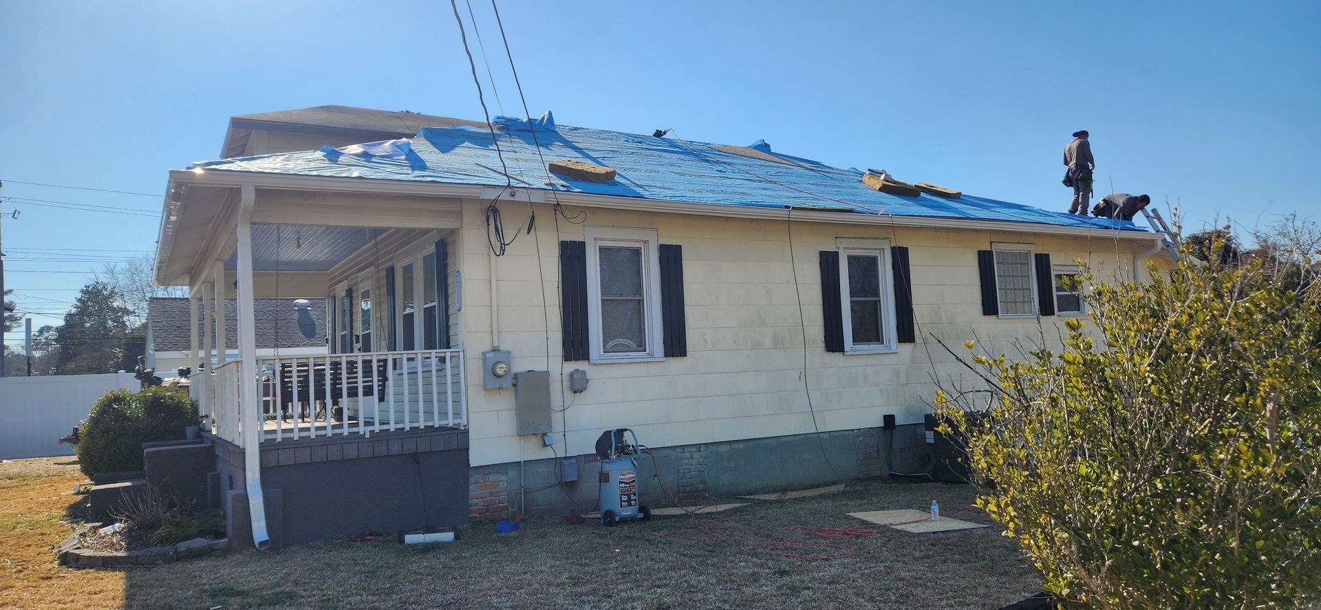 Roof Pro NC crew installing a protective tarp after storm damage near Morehead City, NC