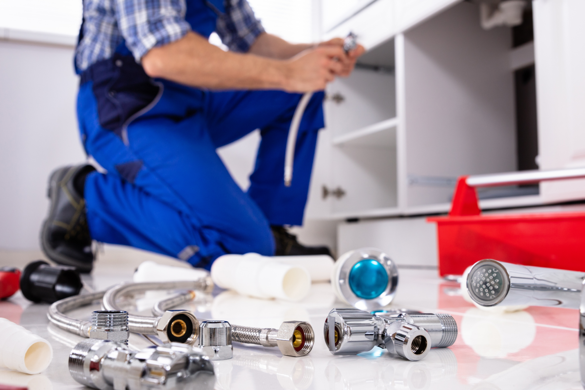 Residential plumber installing a faucet under a kitchen sink