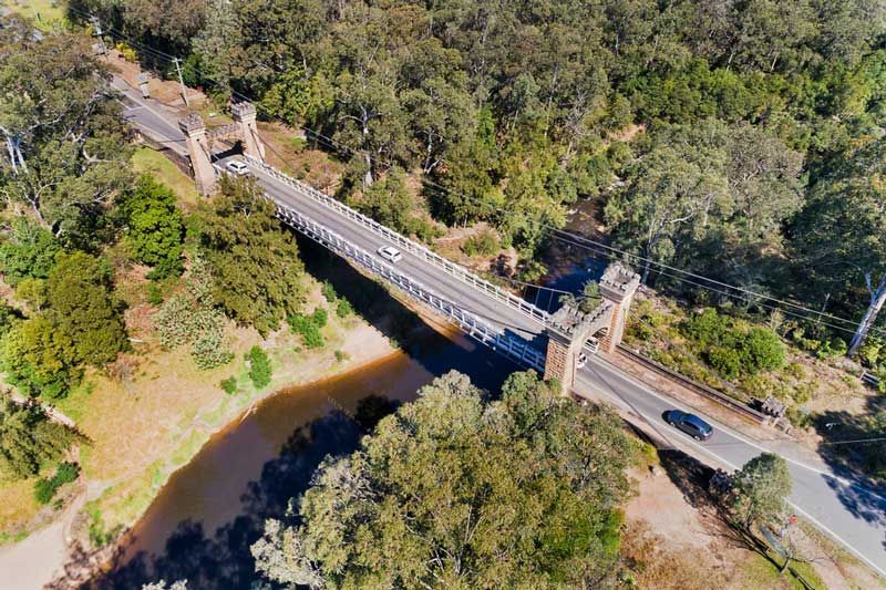 An aerial view of a bridge over a river surrounded by trees — Hydro Excavation in Moss Vale, NSW