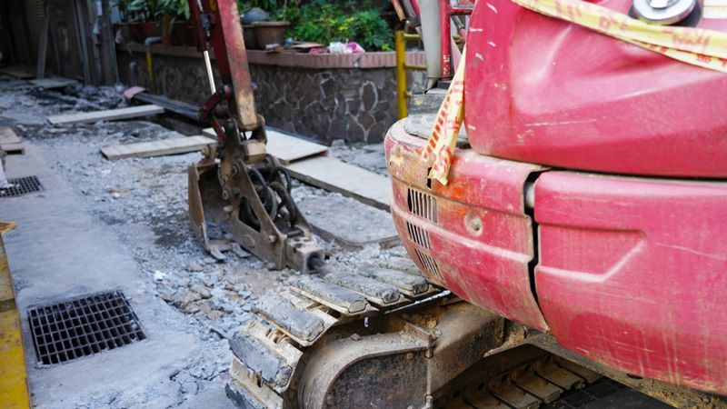 A red excavator is parked on the side of the road — Hydro Excavation in Moss Vale, NSW