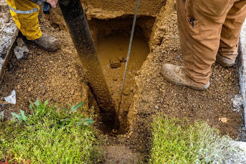 A man is pumping dirt into a hole in the ground — Hydro Excavation in Canberra, NSW