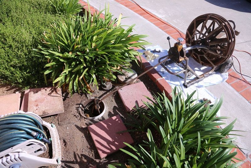 A hose is laying on the ground next to a hose reel — Hydro Excavation in Bowral, NSW