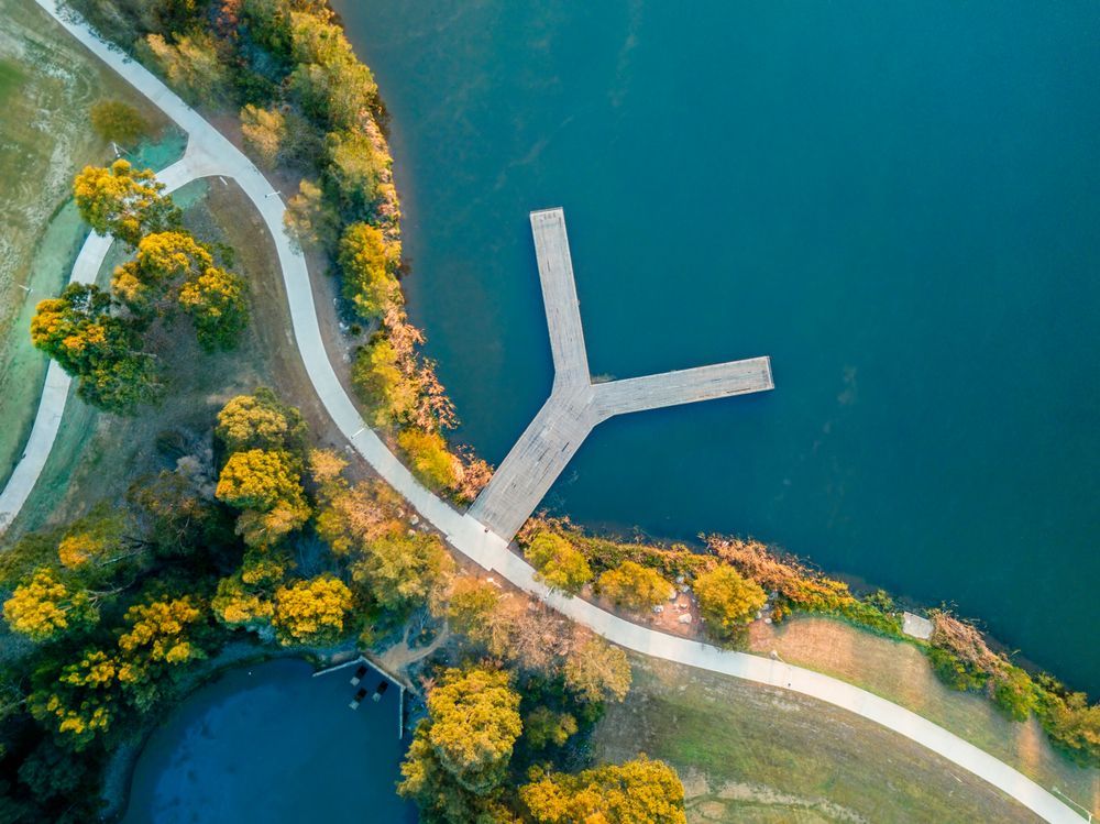 An aerial view of a lake with a dock and a path — Hydro Excavation in Narellan, NSW