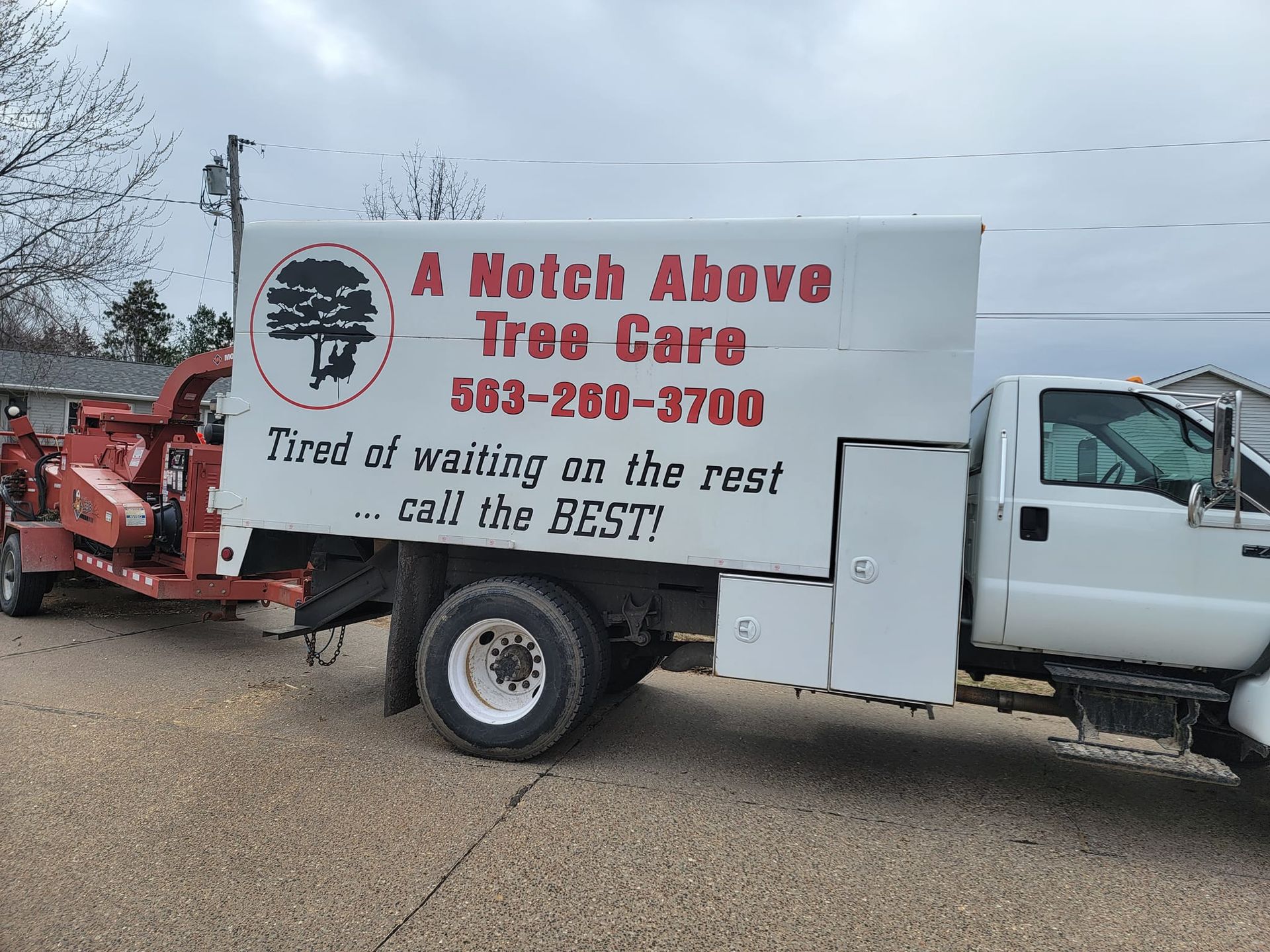 White A Notch Above Free Care truck with logo and phone number parked on a gravel lot
