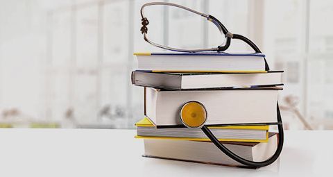 A stack of books with a stethoscope attached to them.