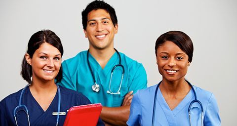 A group of doctors and nurses are posing for a picture.