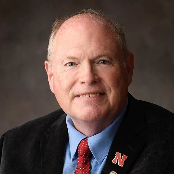 A man in a suit and tie with a n on his jacket