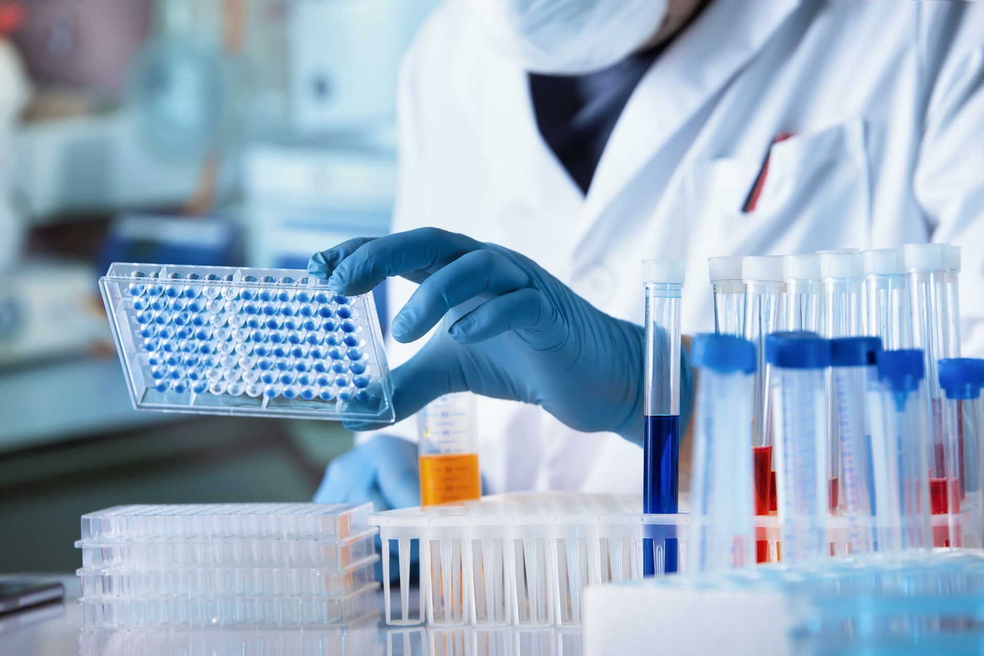 A scientist is holding a petri dish in a laboratory.