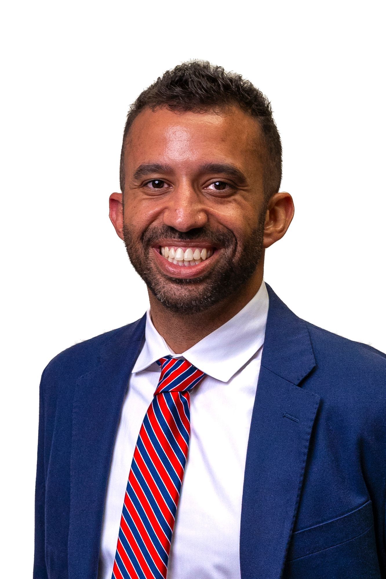 A well-dressed man is smiling for the camera on a white background.