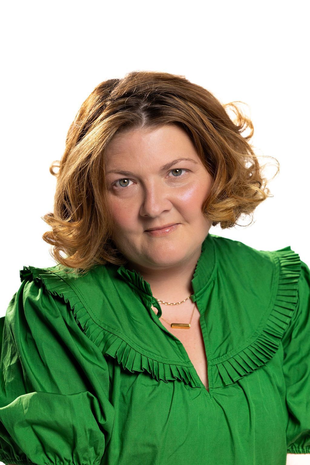 Woman in a green blouse smiling against a white background