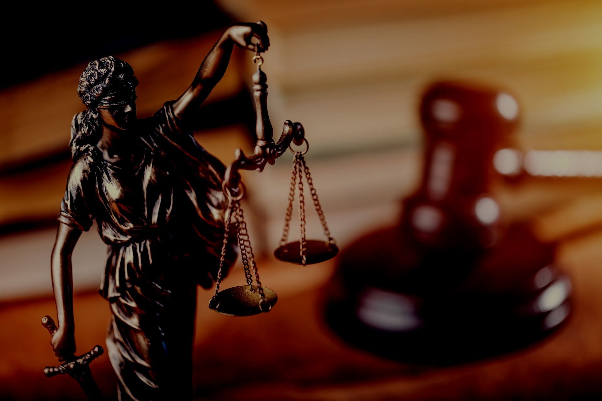 A statue of lady justice holding scales of justice and a gavel.