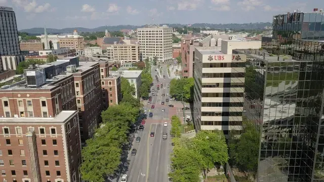 An aerial view of a city street with lots of buildings and trees.