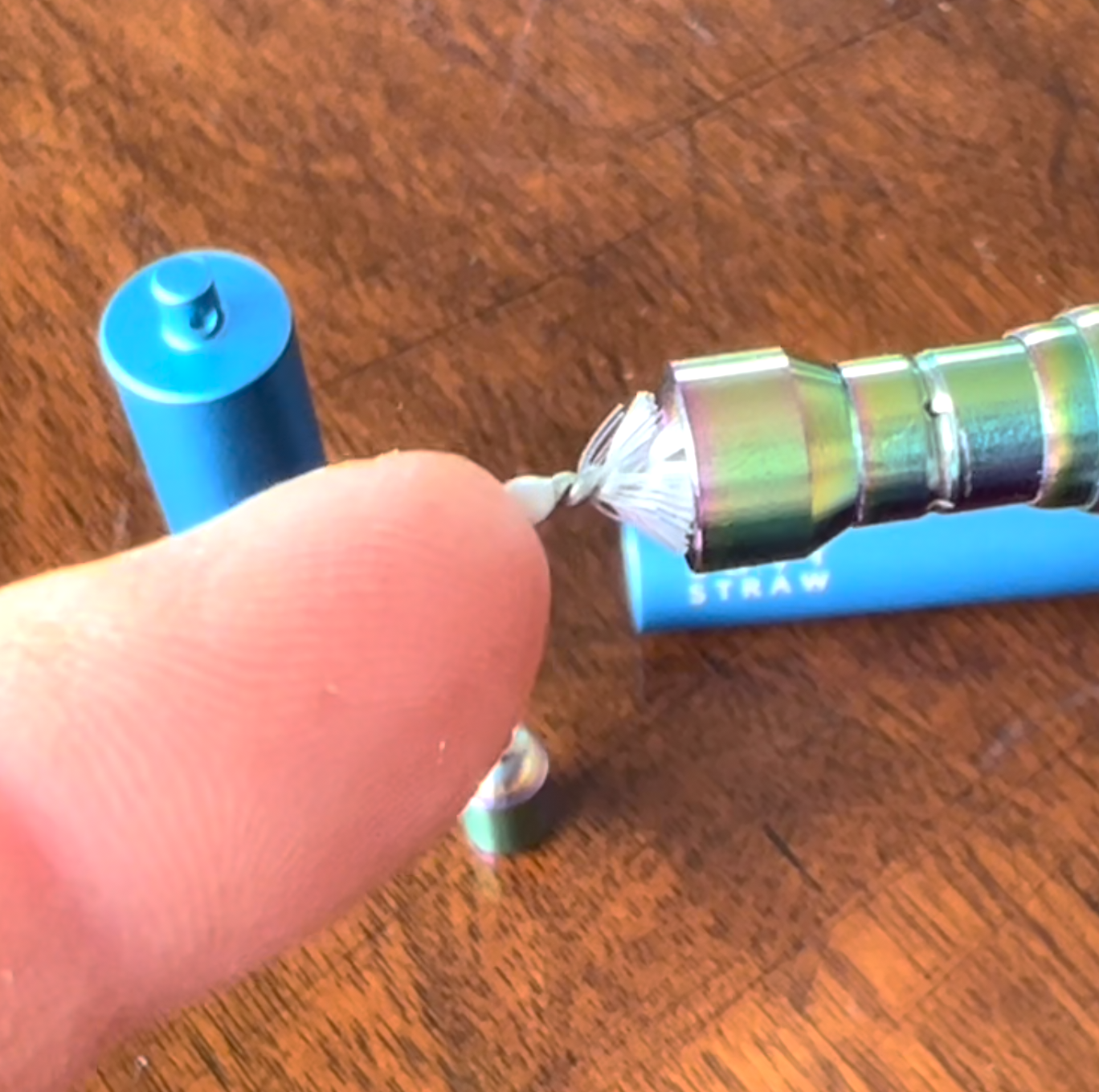 A person is holding a straw in their finger