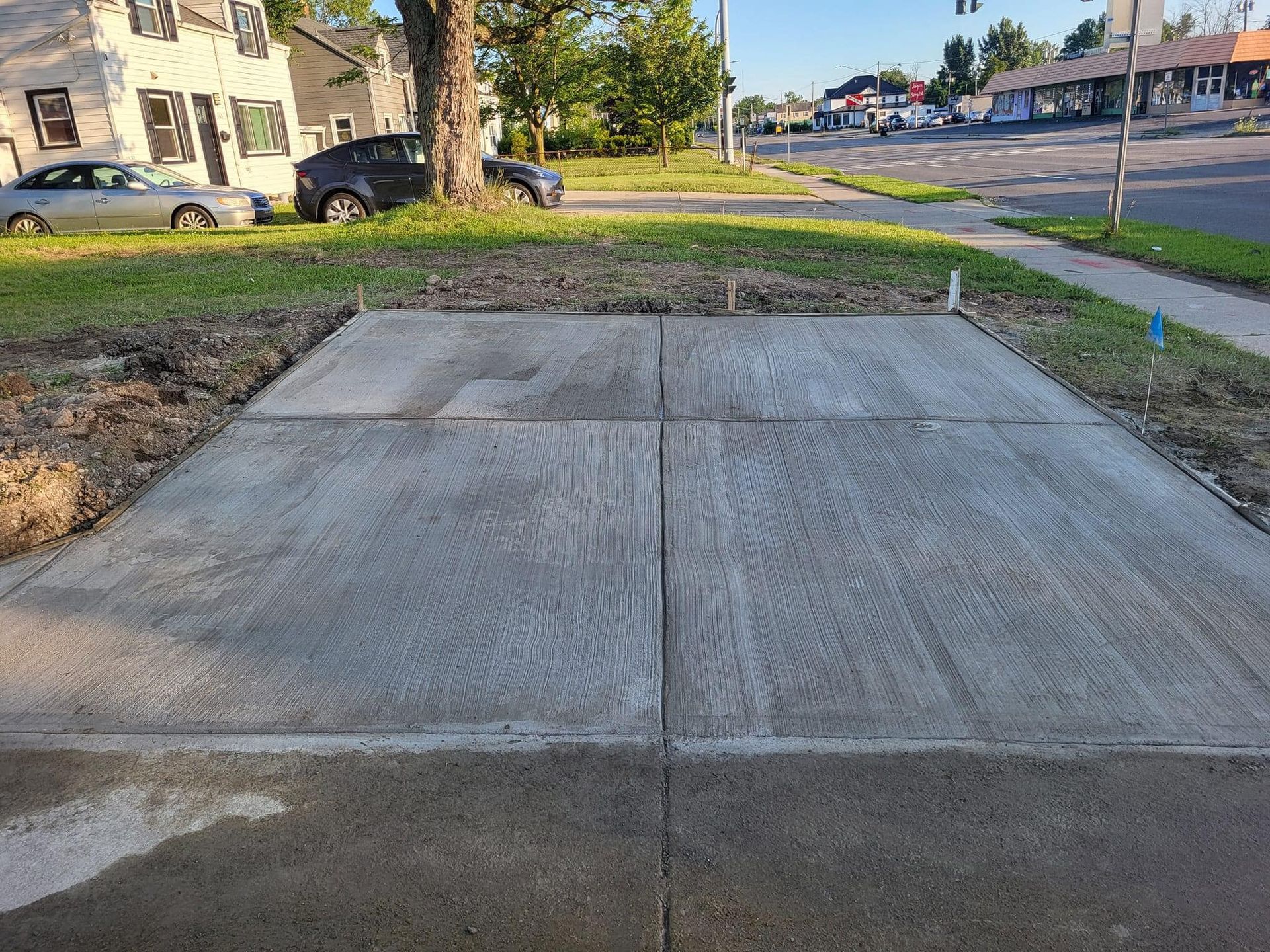 A concrete driveway is being built on the side of the road.