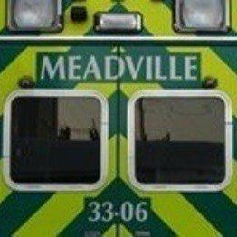 Green and yellow vehicle front labeled “MEADVILLE” with two square windows and number 33-06