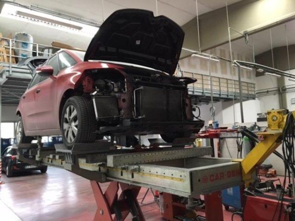 Un'auto rossa su un ponte sollevatore