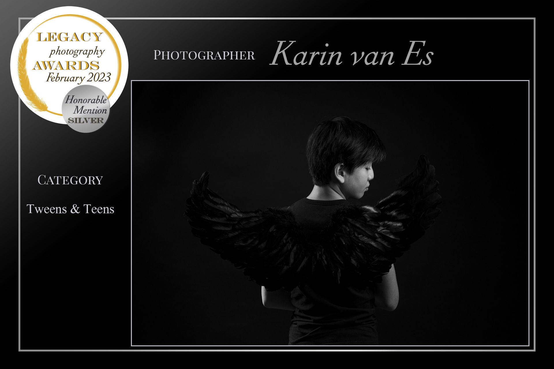 Een kind met zwarte vleugels, met de rug naar de camera, op een foto ingelijst door een fotografieprijs.