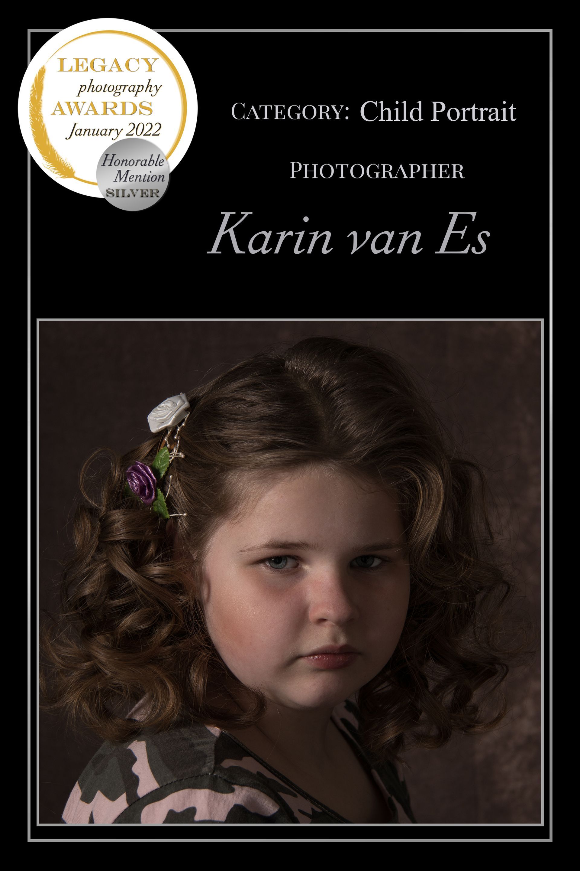 Portret van een kind door Karin van L's. Het jonge meisje heeft krullend bruin haar en draagt ​​een shirt met een patroon.