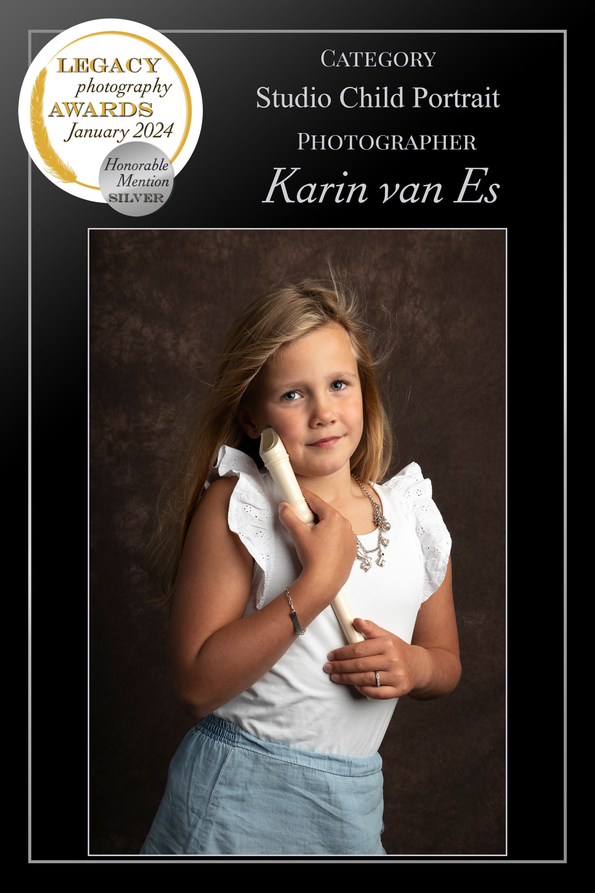 Meisje in witte top en spijkerrok, met een houten voorwerp in haar handen, studiofoto tegen een bruine achtergrond.