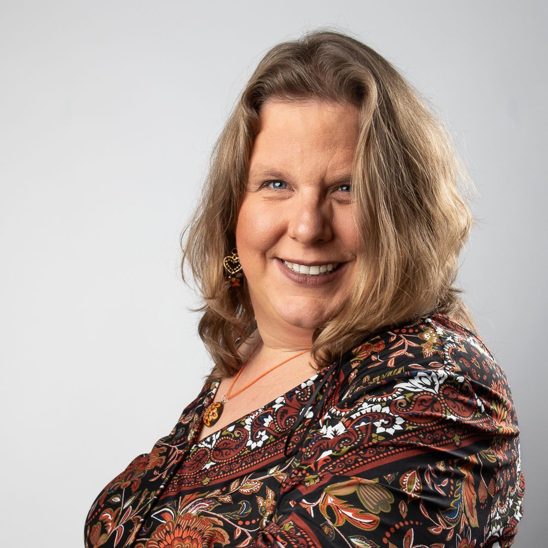 Vrouw met schouderlang, donkerblond lachend.