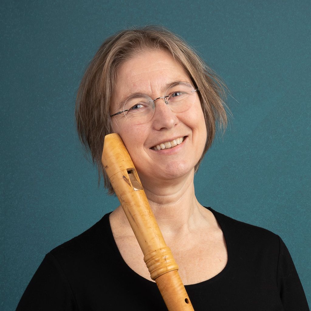 Handen die akkoorden spelen op een digitaal pianoklavier, met armbanden en een wit overhemd aan.