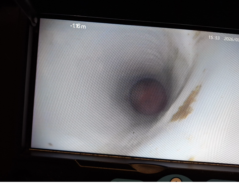 Il monitor mostra una visione bianca simile a un tunnel con un centro circolare scuro e una piccola macchia rossastra.