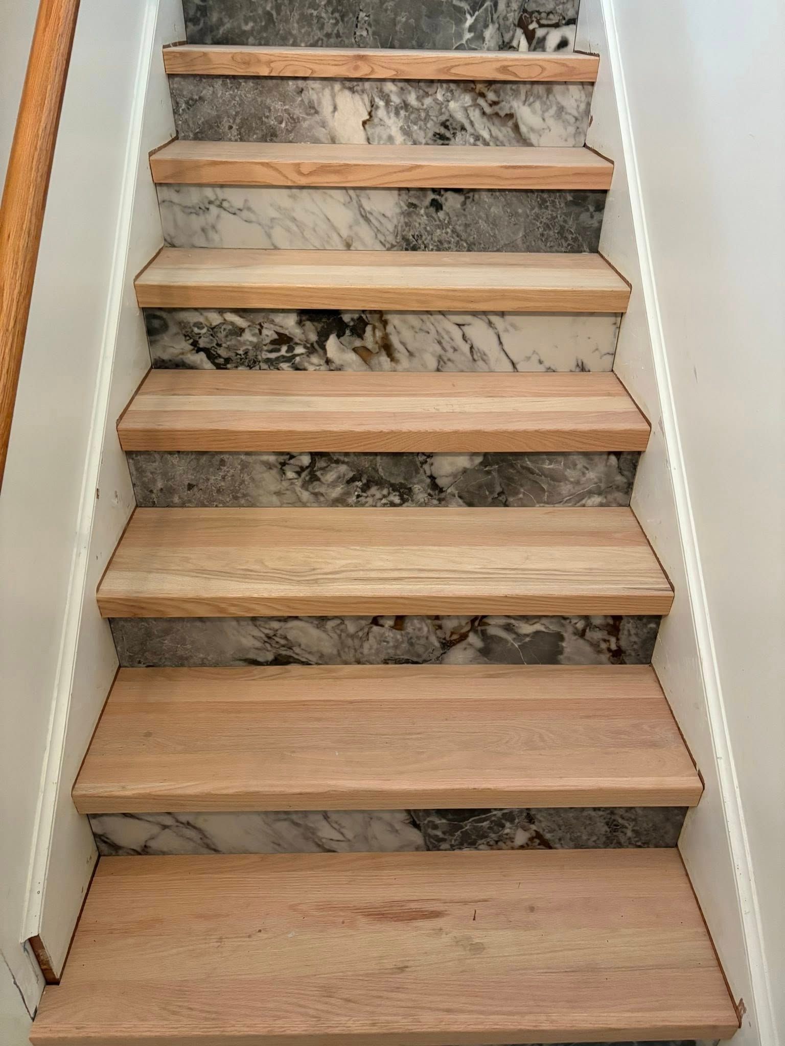 Wooden staircase with marble-patterned risers. 