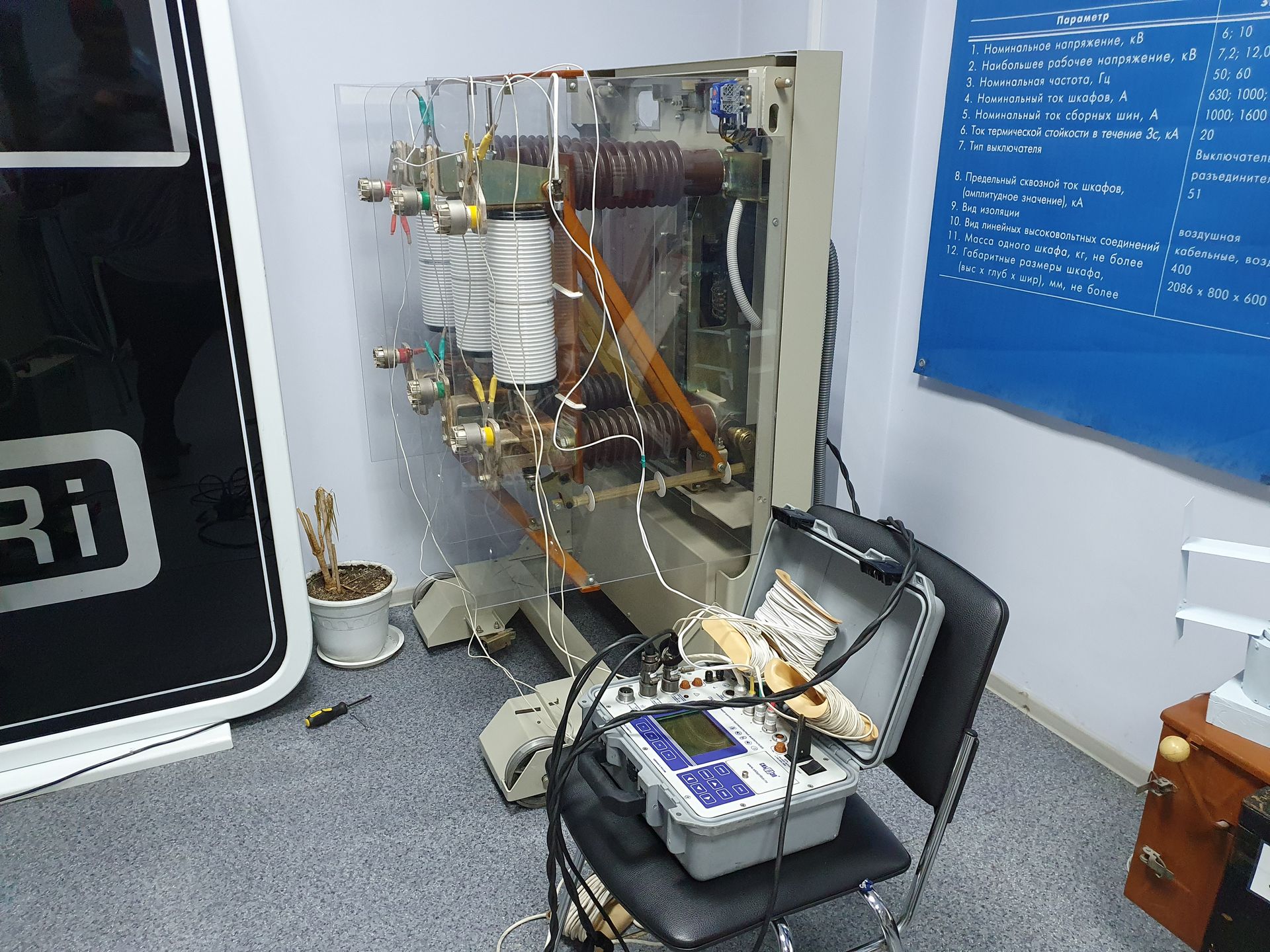 Apparecchiature elettroniche a vista con fili e un piccolo dispositivo su un banco da lavoro in una stanza simile a un laboratorio.