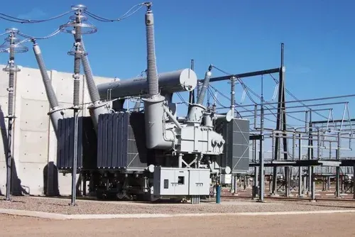 Sottostazione elettrica con trasformatori, linee elettriche e strutture metalliche in un'area industriale asciutta.