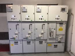 Armadi elettrici industriali con interruttori ed etichette di avvertenza a muro