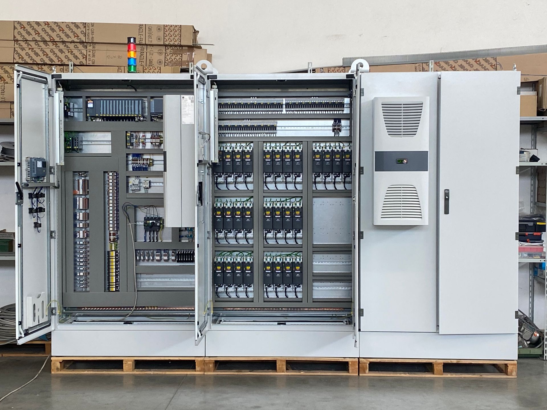 Armadio elettrico industriale con cablaggio a vista e componenti su pallet all'interno