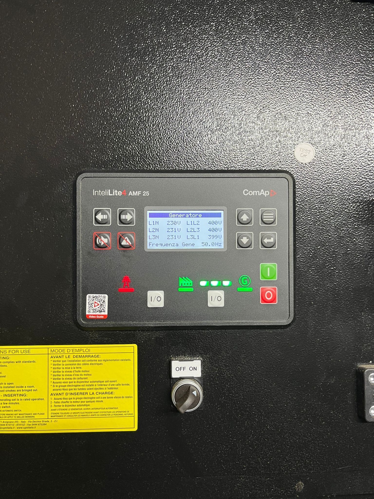Pannello di controllo con piccolo display blu e pulsanti colorati su uno sportello della macchina di colore nero con superficie ruvida.