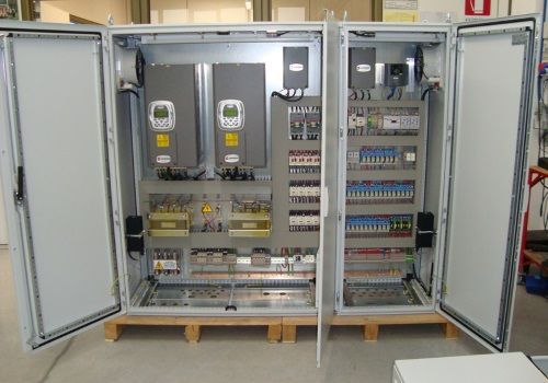 Armadio elettrico aperto con cablaggio, interruttori e componenti industriali all'interno.