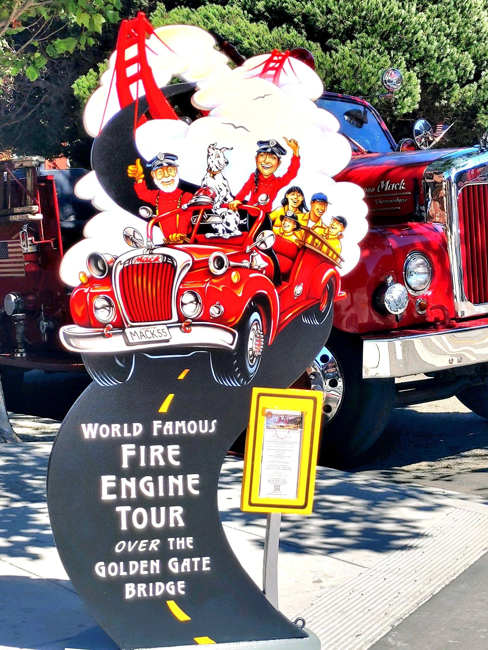 Decorated red fire engine in a parade near a sign reading “World Famous Fire Engine Tour”