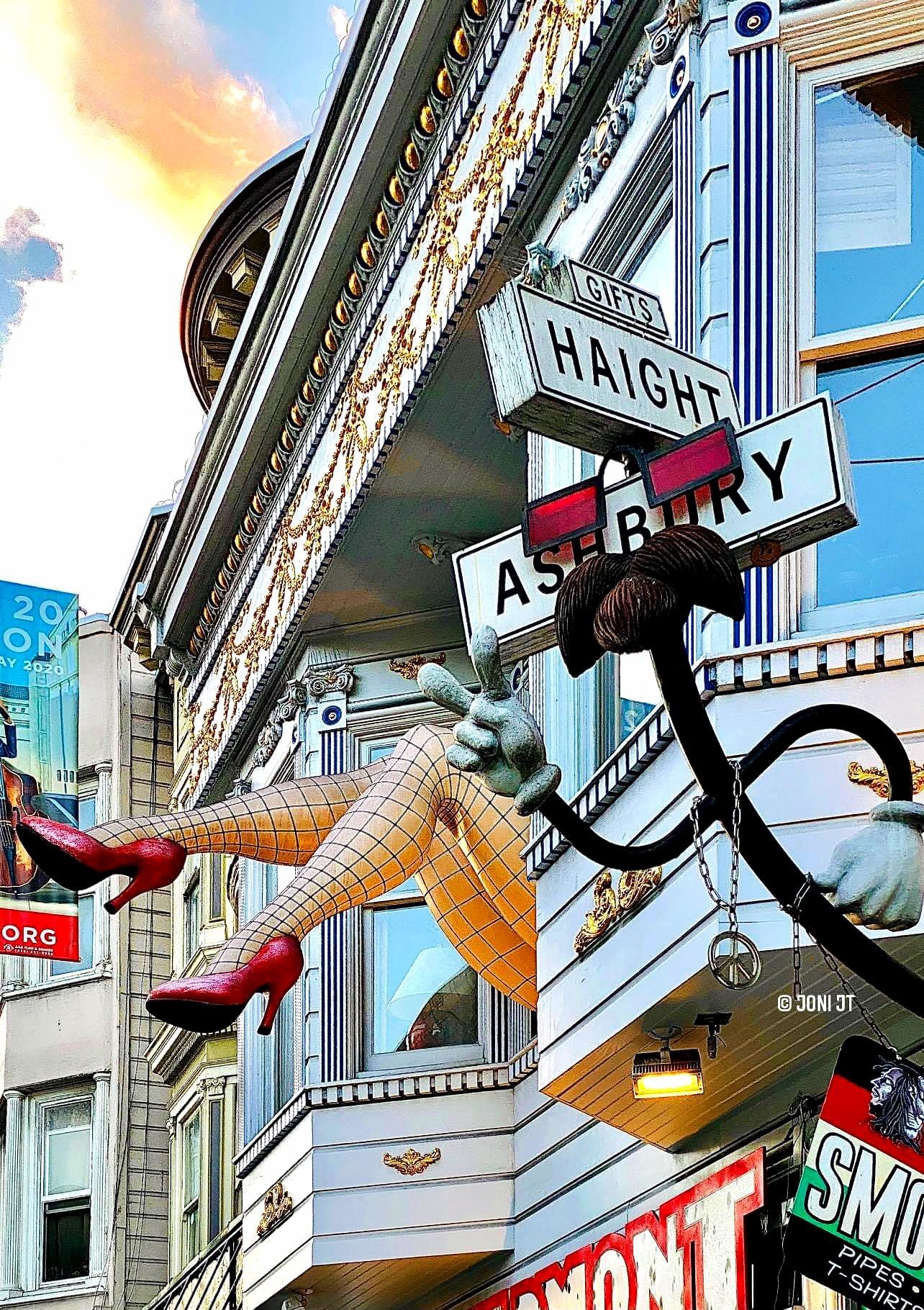 Neon signs and a large armature on a bright city street, viewed from below