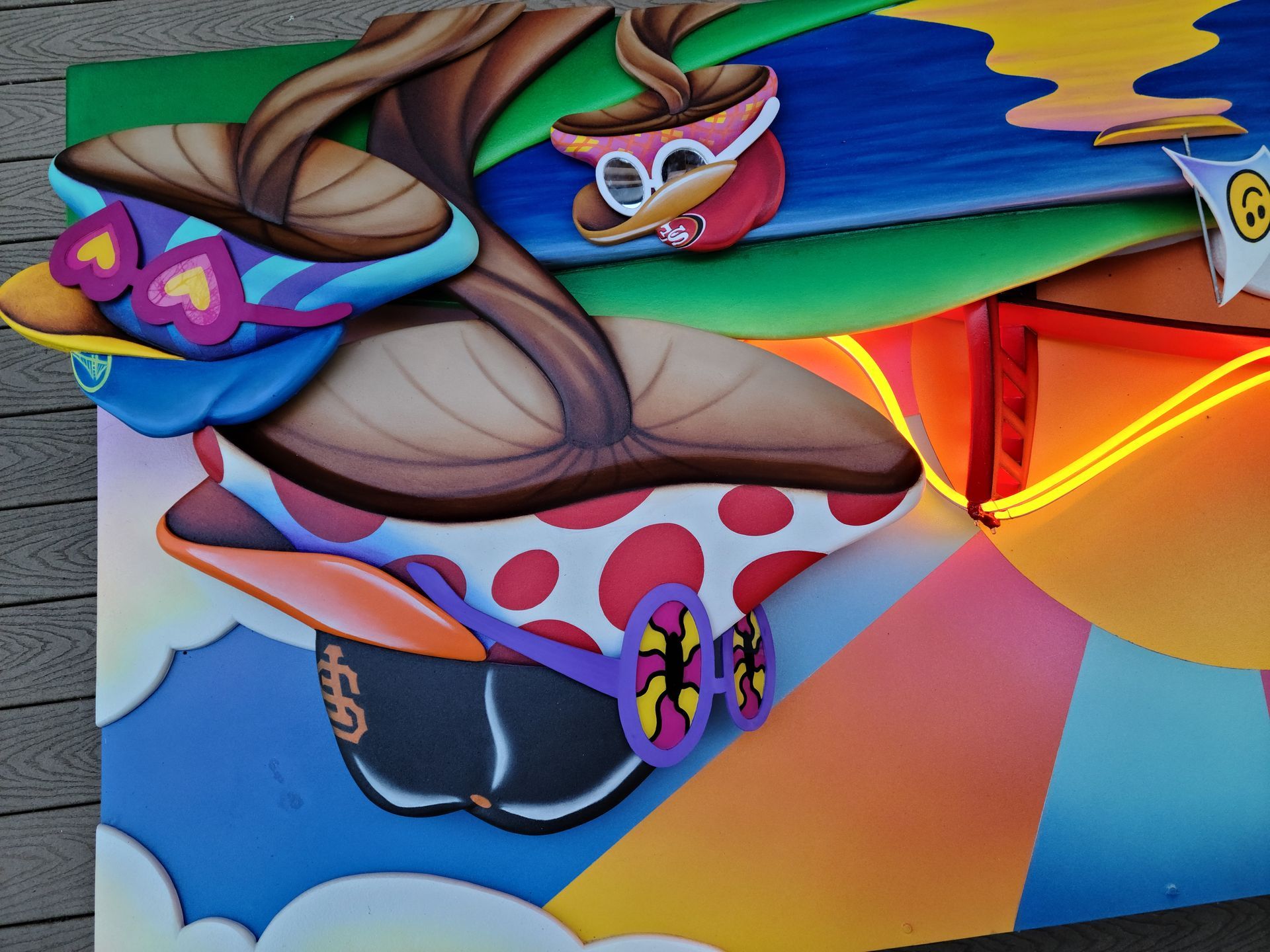Colorful mural of a masked acrobat spinning on a rope, with bold blue, pink, and orange geometric shapes