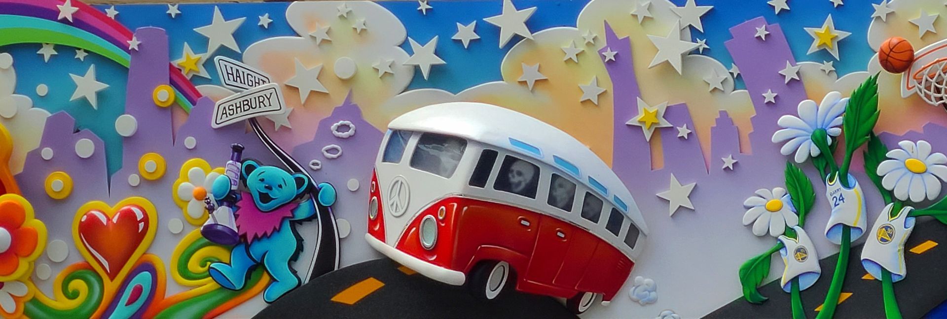 Colorful papercraft scene with a red-and-white bus, flowers, stars, and butterflies on a pastel background