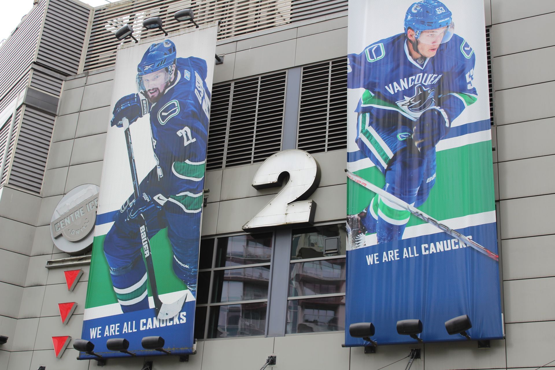 Ingang van de arena met twee spandoeken van spelers van de Vancouver Canucks aan weerszijden van een groot nummer 2.