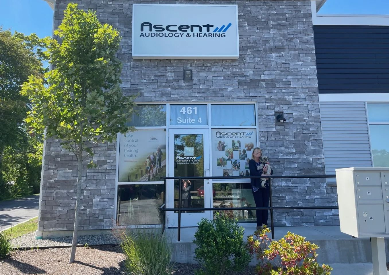 Ascent office storefront with stone facade, glass entrance, and a person standing outside