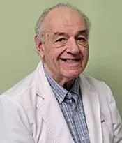 Smiling doctor in a white coat against a light green background