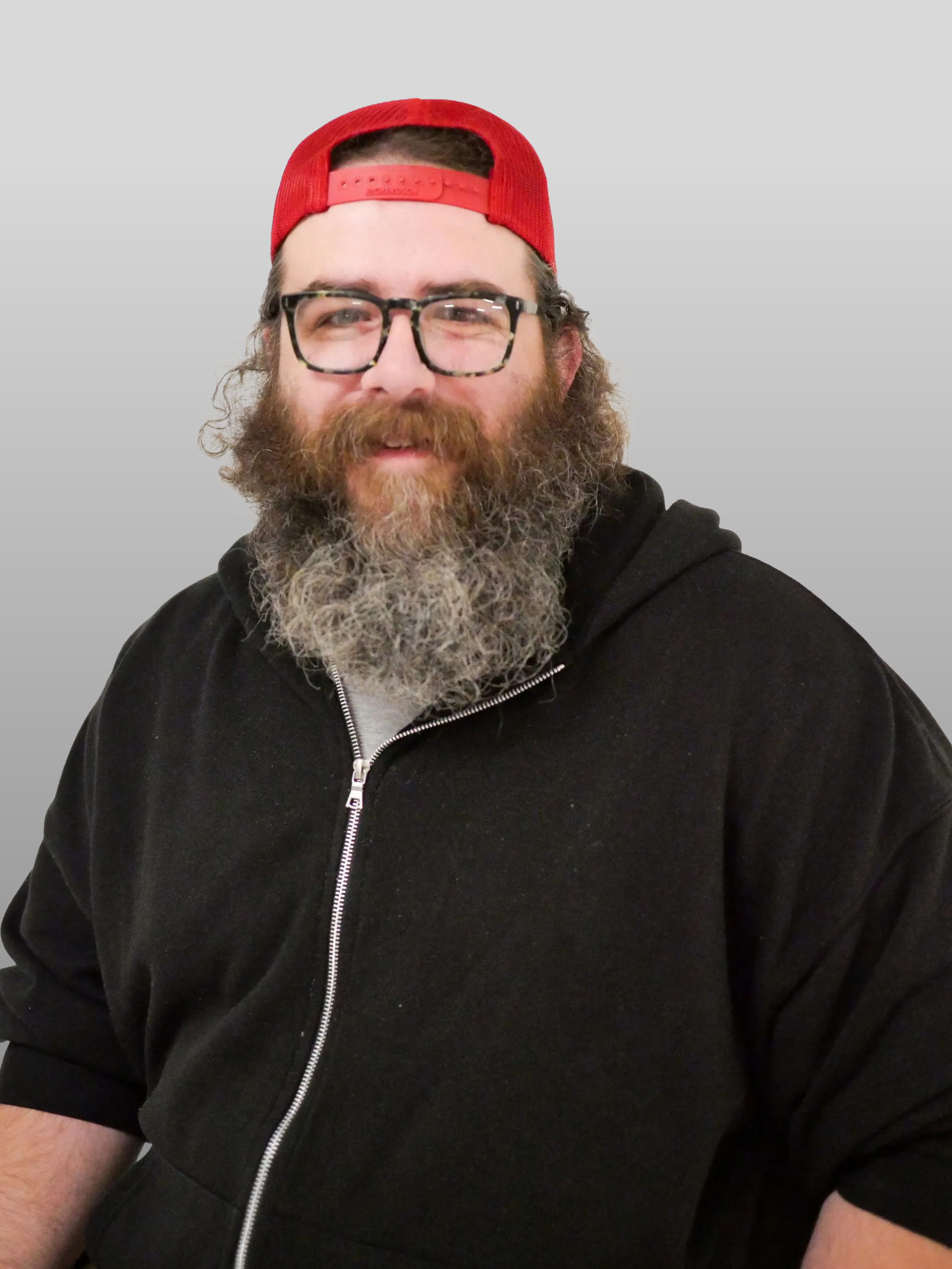 A man with a beard wearing glasses and a red hat