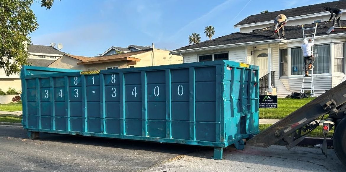 Quality Bin Inc. roll-off dumpster on a residential street during a roof tear-off
